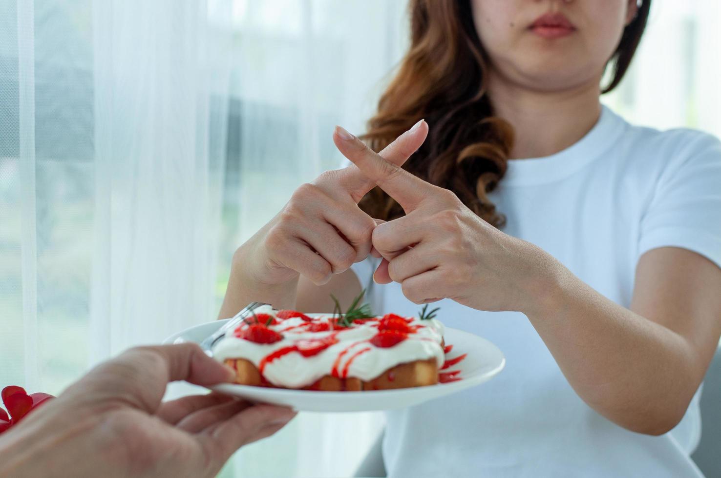 Healthy women refuse to eat bread containing whipped cream and cheese. No carbohydrate and trans fats for good shape and good health. photo