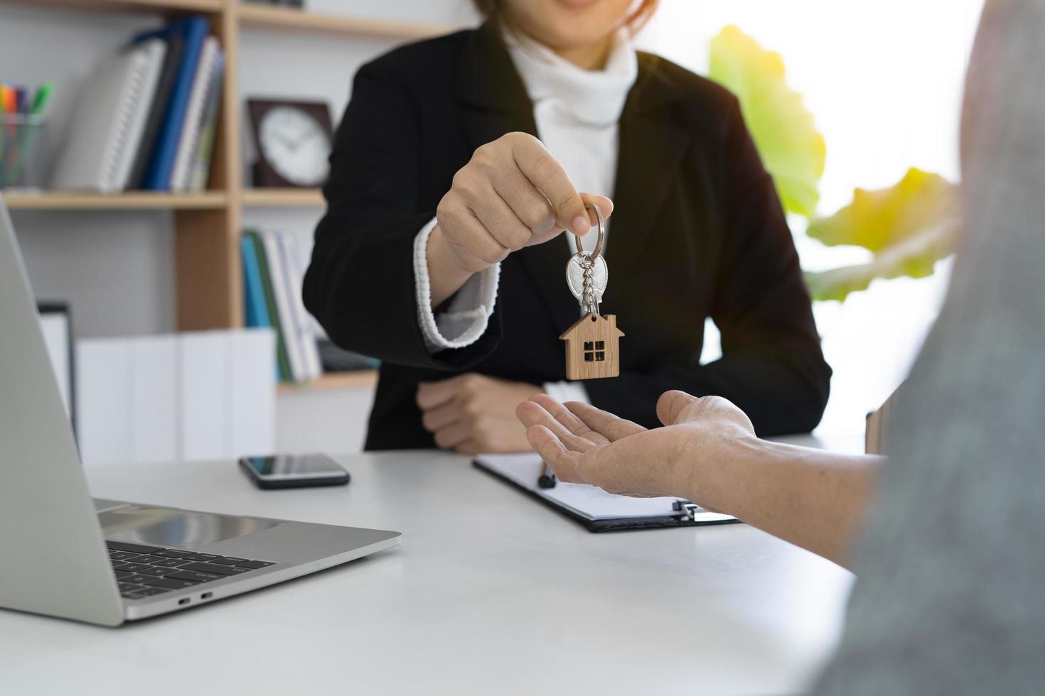 Real estate agents give key to homeowner  after agreement to buy-sell. photo