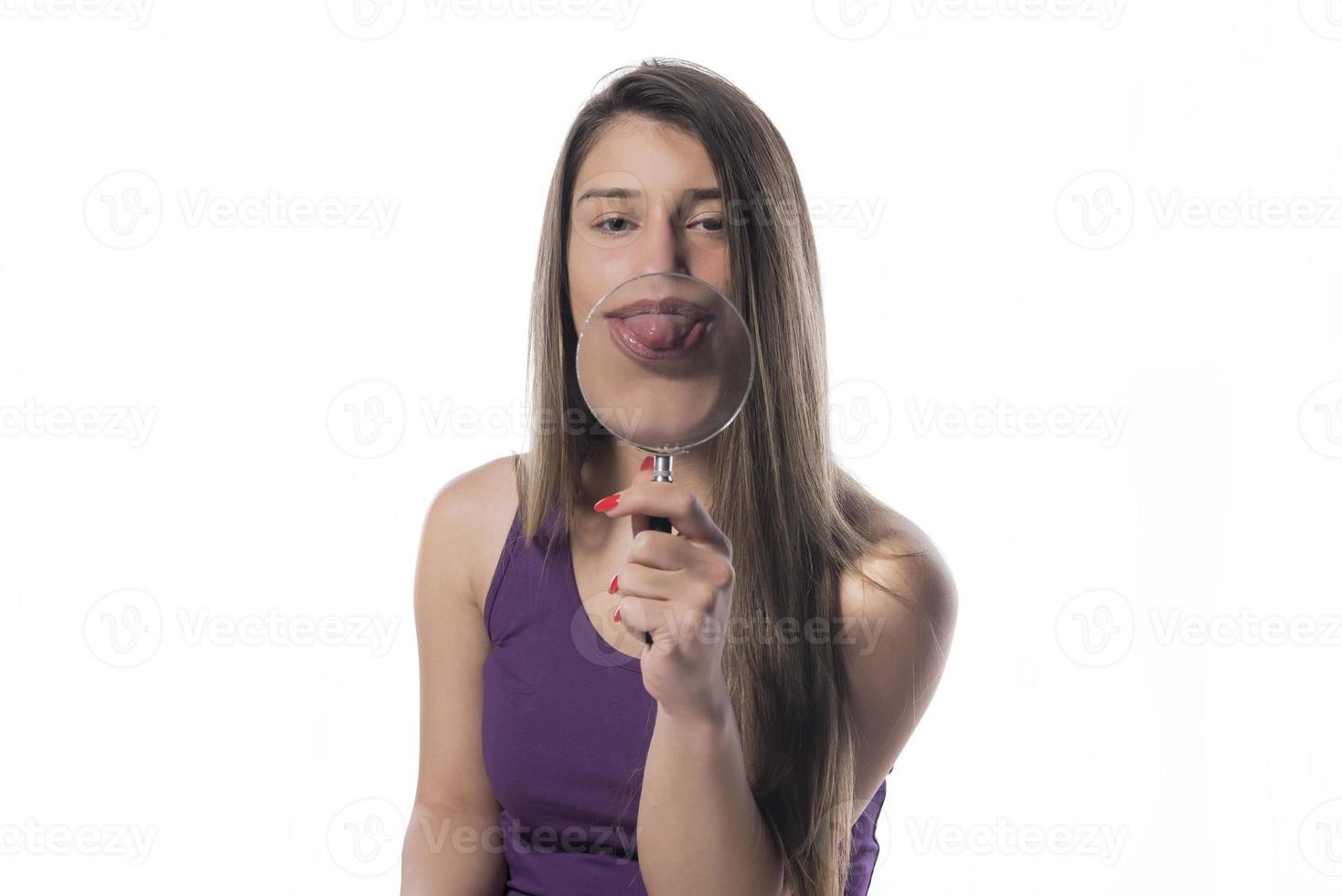 Laughing woman holds a magnifying glass in front of her mouth photo