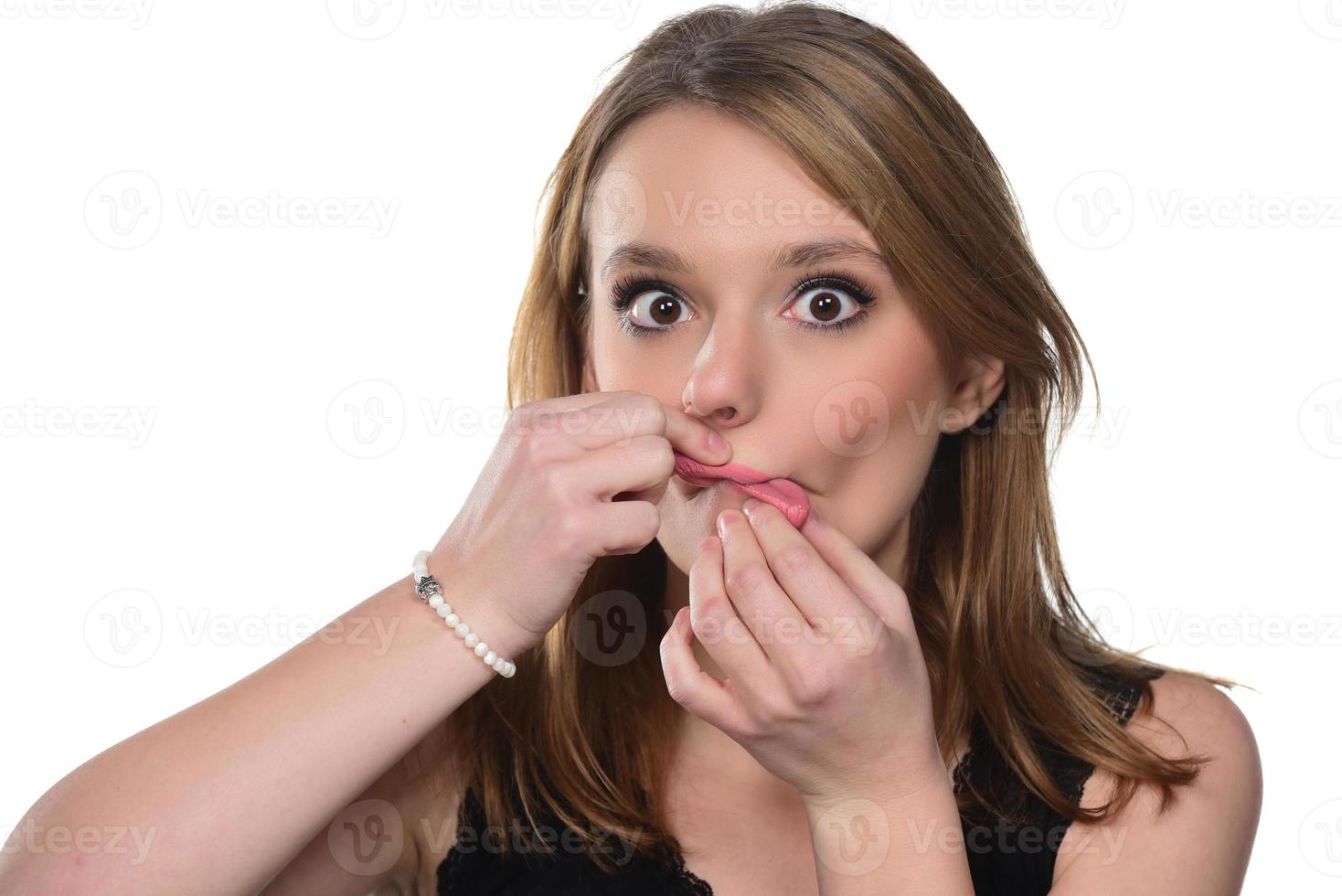 Close up studio portrait of cheerful blonde hipster girl going crazy making funny face photo