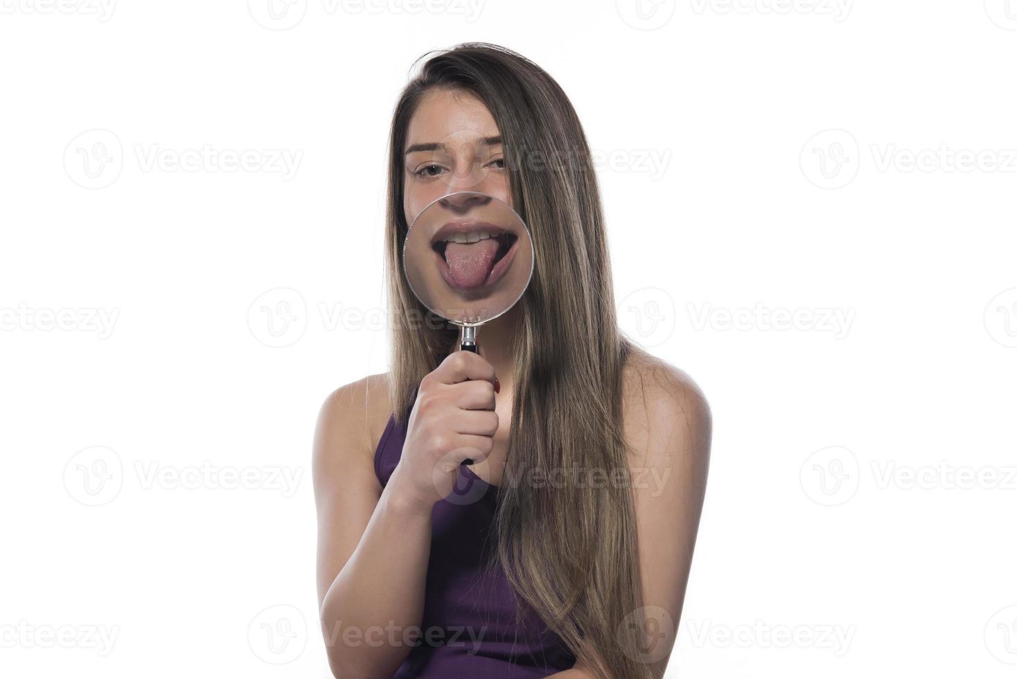 Laughing woman holds a magnifying glass in front of her mouth photo