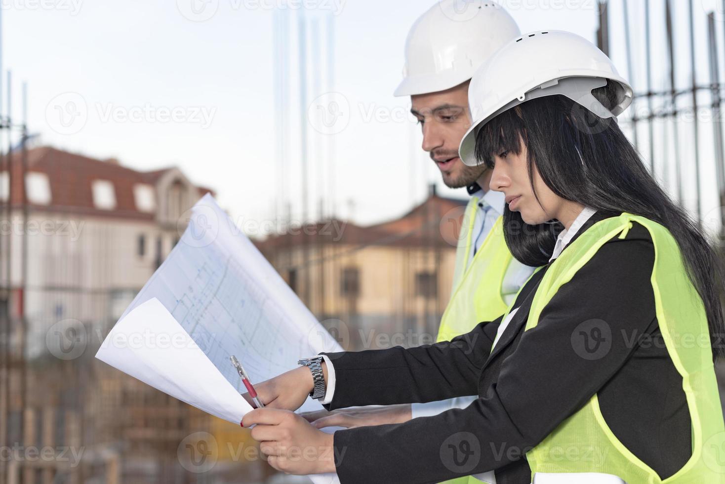 Construction manager and engineer working on building site photo