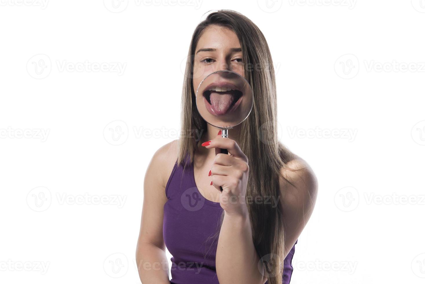 Laughing woman holds a magnifying glass in front of her mouth photo