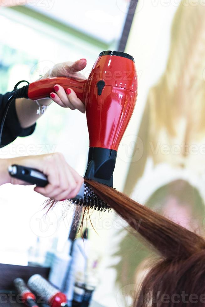 Professional hairdresser working with client in salon, closeup photo