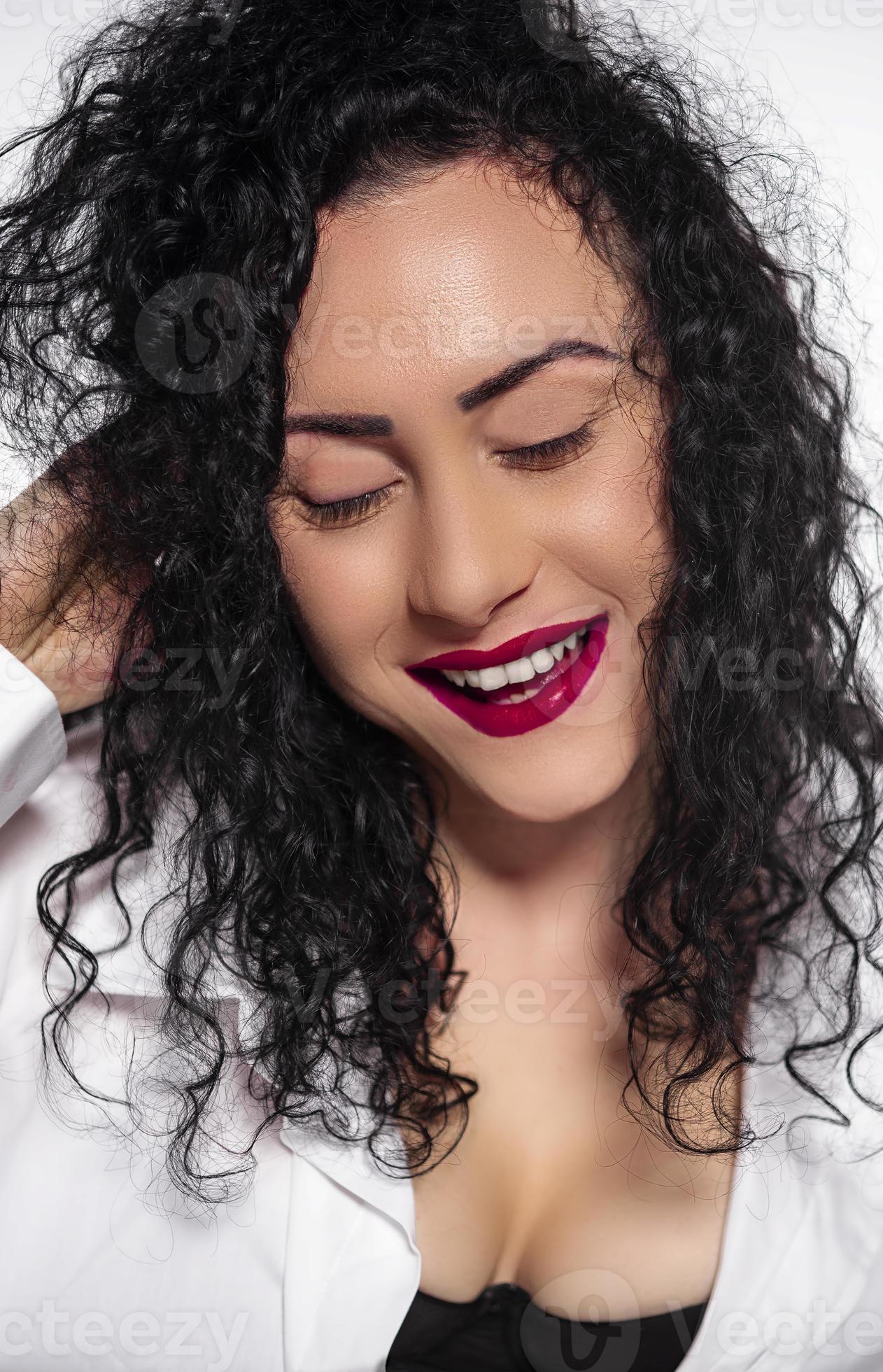 beautiful female with curly hair wearing black bra and white male shirt