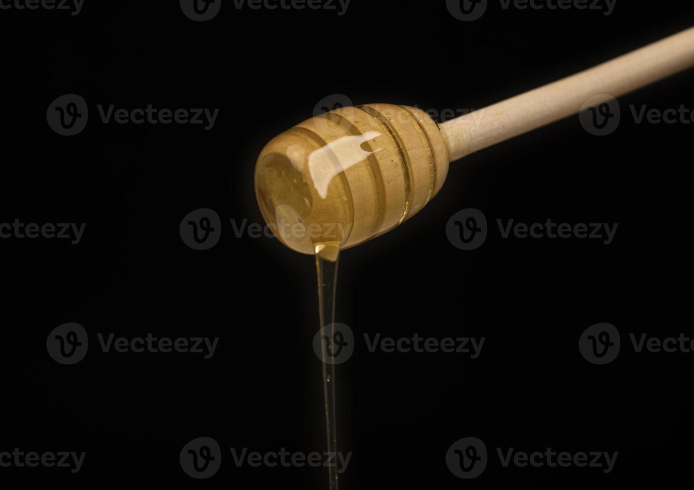 dripping honey on wooden dipper white background with room for copy space photo