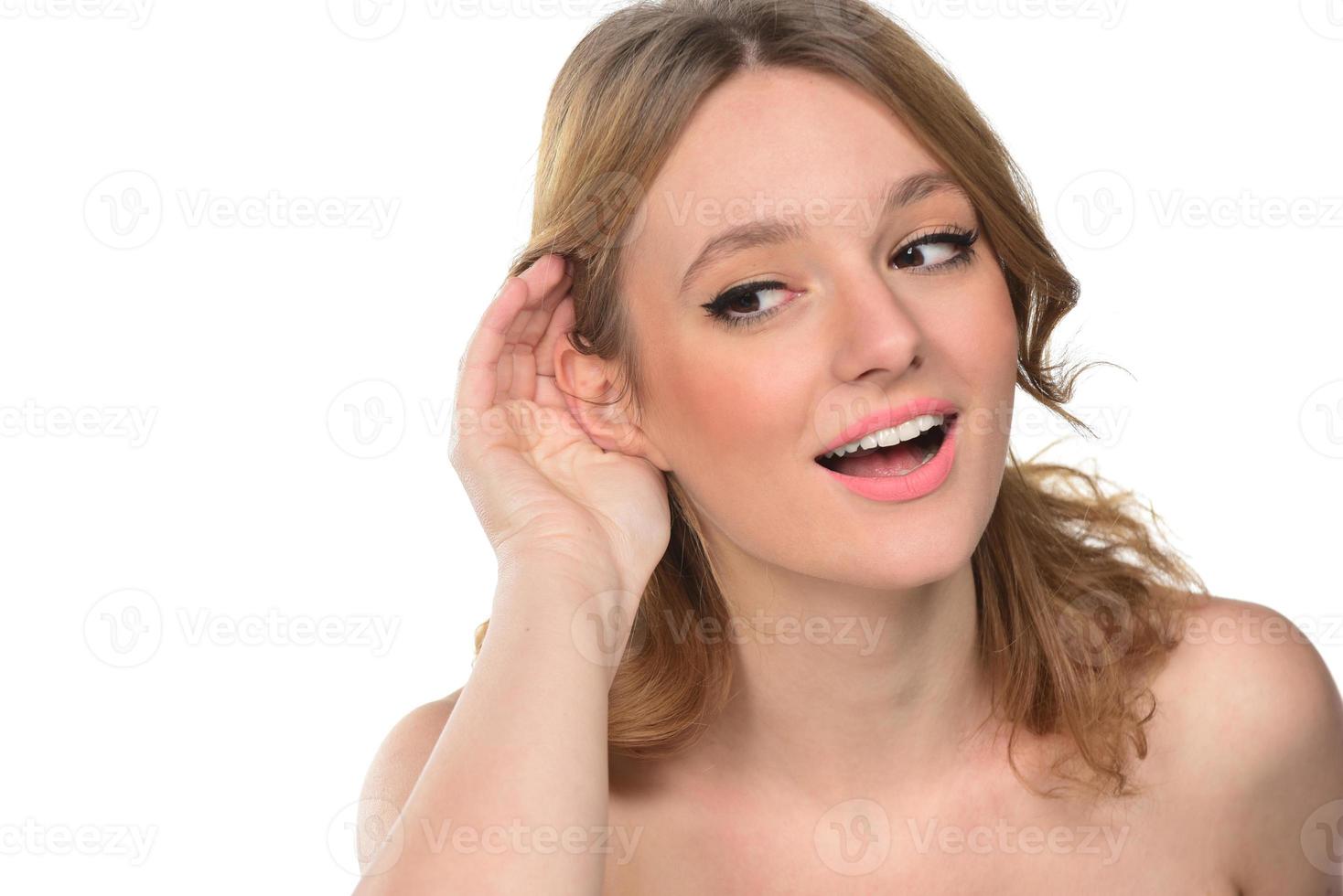 Closeup of Woman holds her hand near ear and listens carefully photo