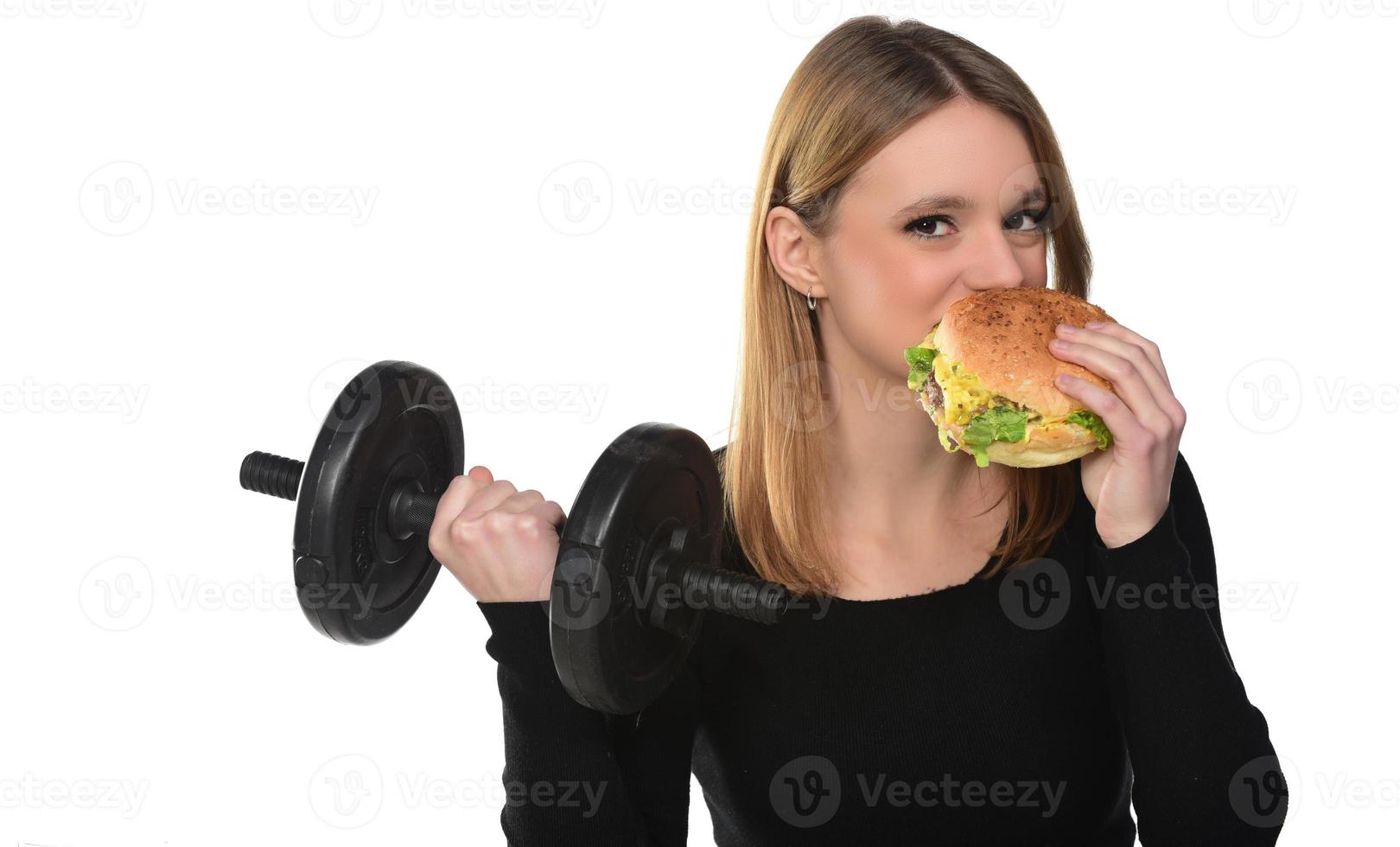 Woman lifts weights eating a sandwich photo