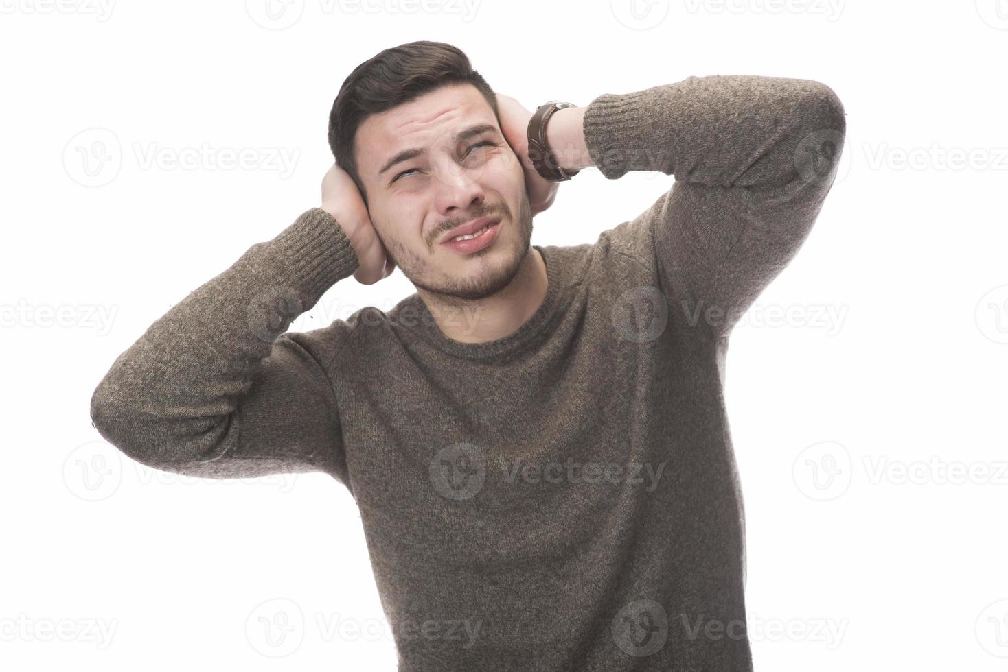 Stop that loud noise. Standing plain young man sad and depressed suffering sorrow and pain screaming desperate with hands on face against  white background. Sadness emotion concept photo