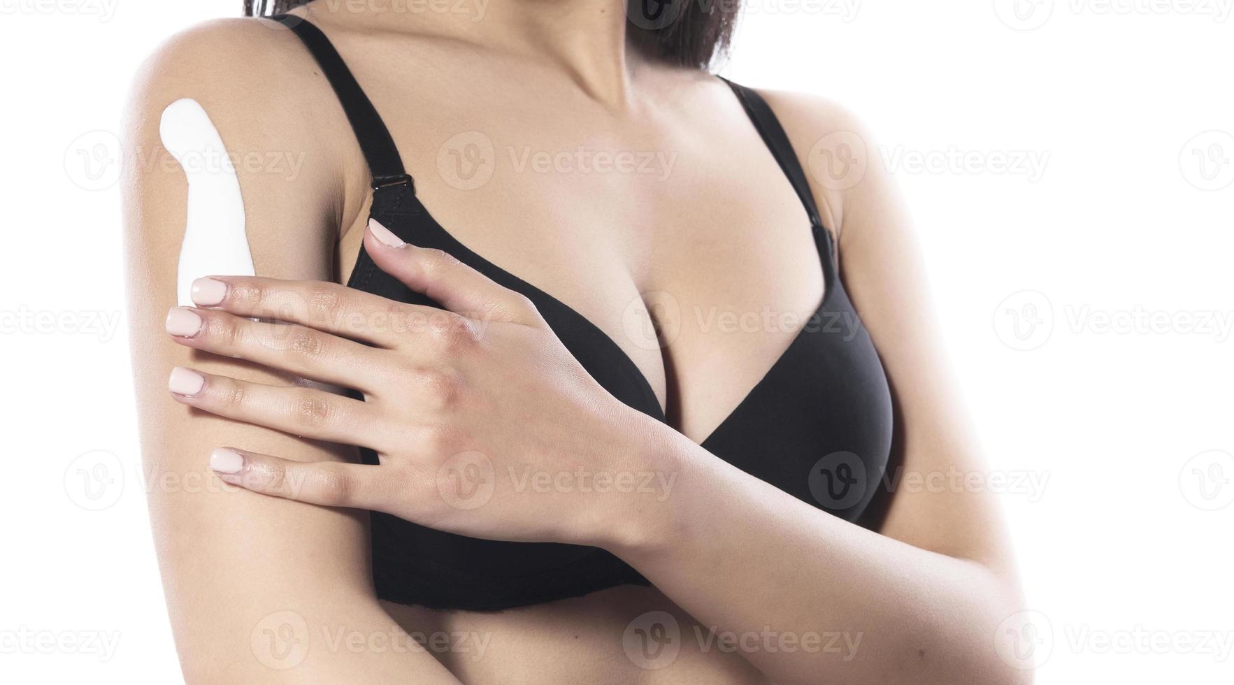 woman applying moisturizer cream on her shoulder, isolated on white photo