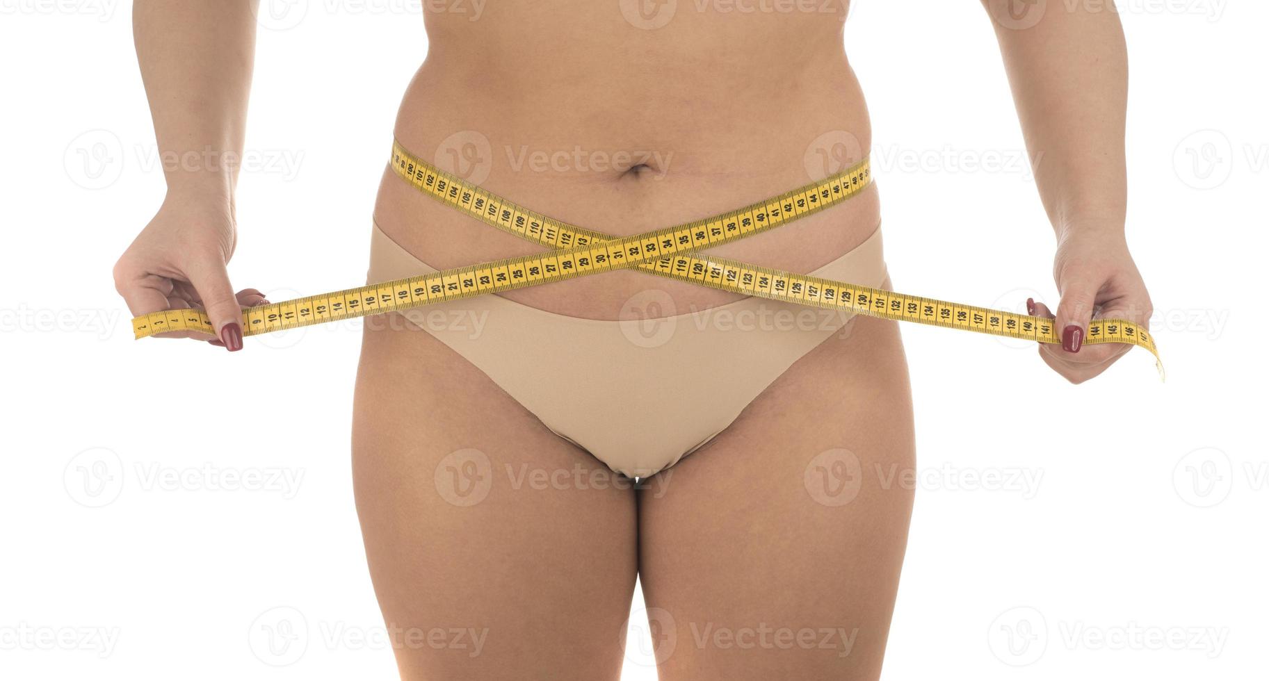 fat woman measuring her stomach overweight, obesity. Isolated on white background. photo
