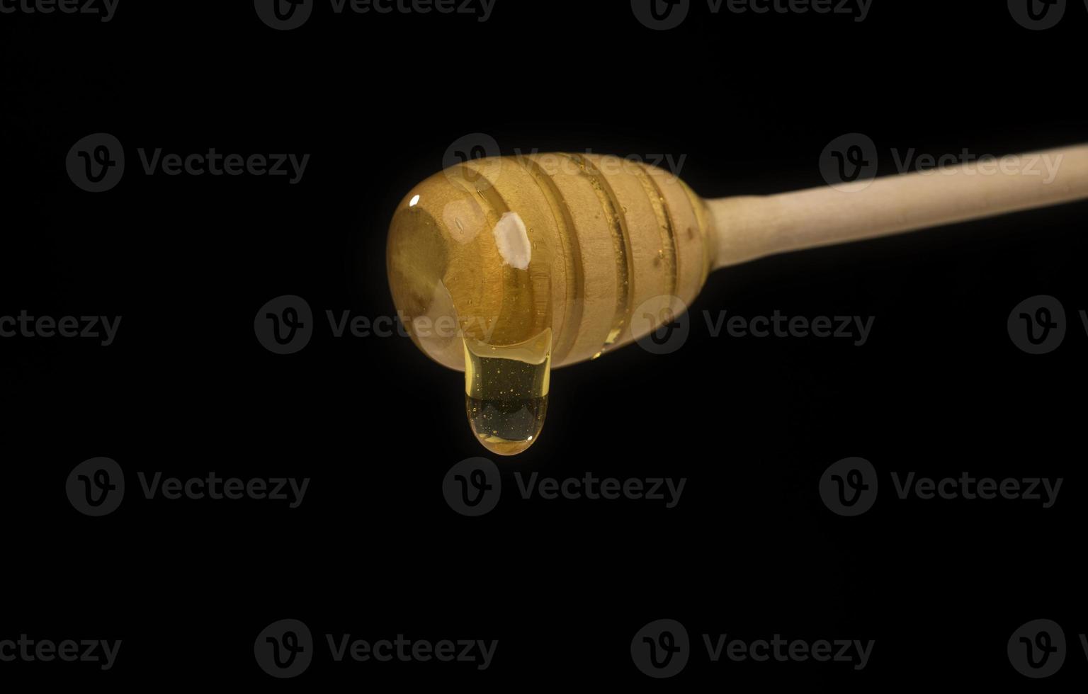 goteo de miel sobre fondo blanco de cazo de madera con espacio para espacio de copia foto