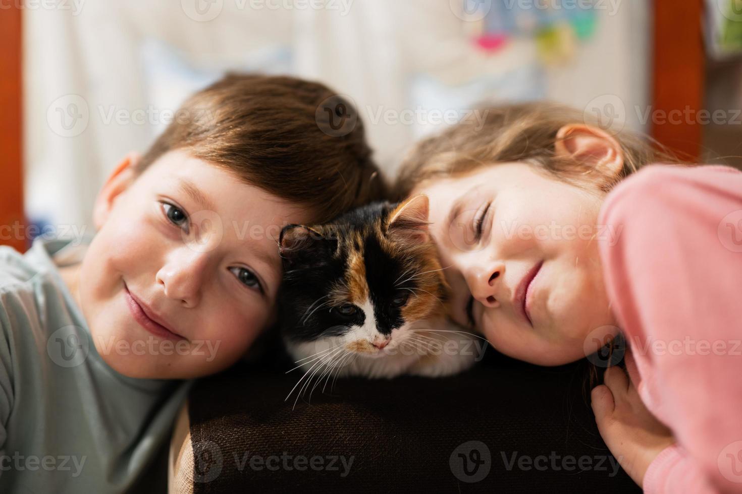 Brother and sister with kitty cat. Children's love for pets. photo