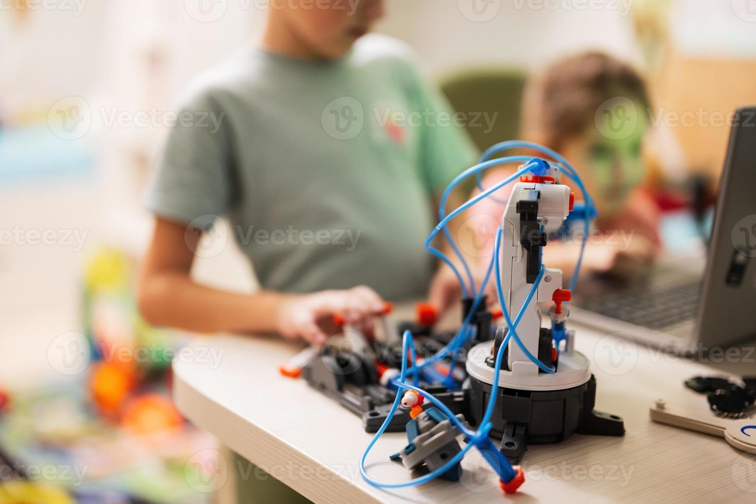 Children learning repairing getting lesson control robot arm, robotic machine arm in home workshop, technology future science education. photo