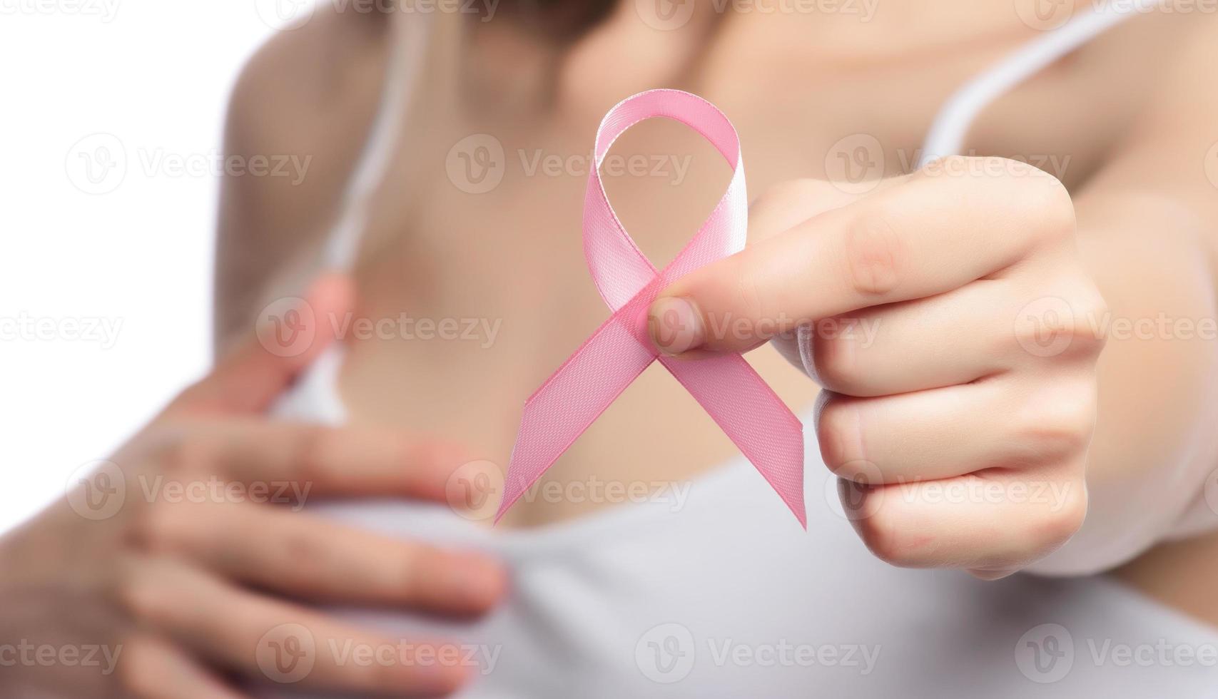 mes de concientización sobre el cáncer de mama de octubre rosa, mano de mujer con cinta rosa foto