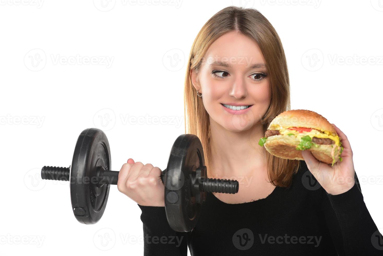 Woman lifts weights eating a sandwich photo