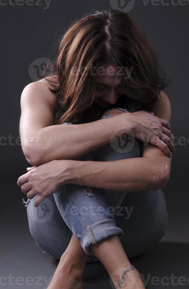joven mujer hermosa con expresión dolorosa sosteniendo su vientre sufriendo dolor menstrual acostada triste en la cama de su casa con calambres en el estómago en el concepto de salud femenina foto