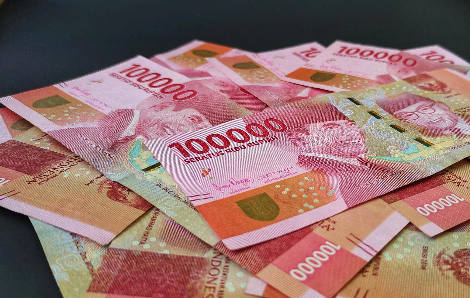 Photos of Indonesian banknotes Rp. 100,000. Indonesian rupiah currency isolated on black background