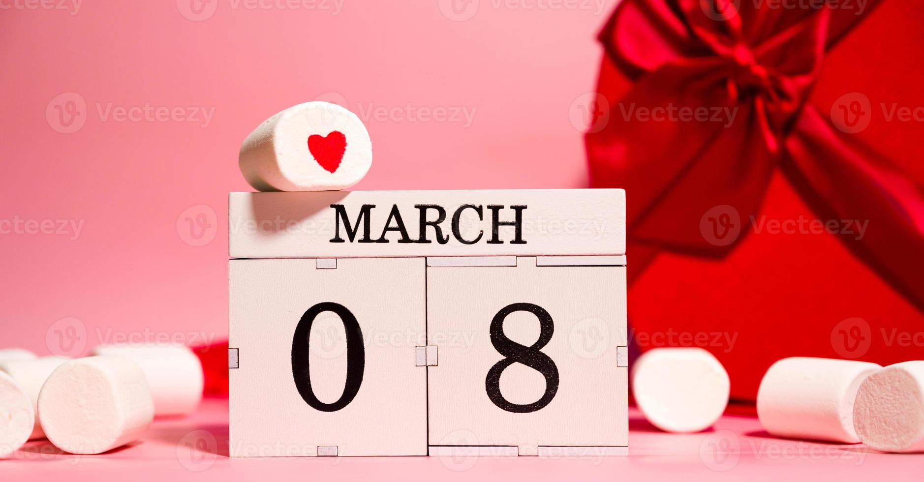 Women's day creative banner with heart shaped gifts, marshmallows and calendar with 8 march date photo