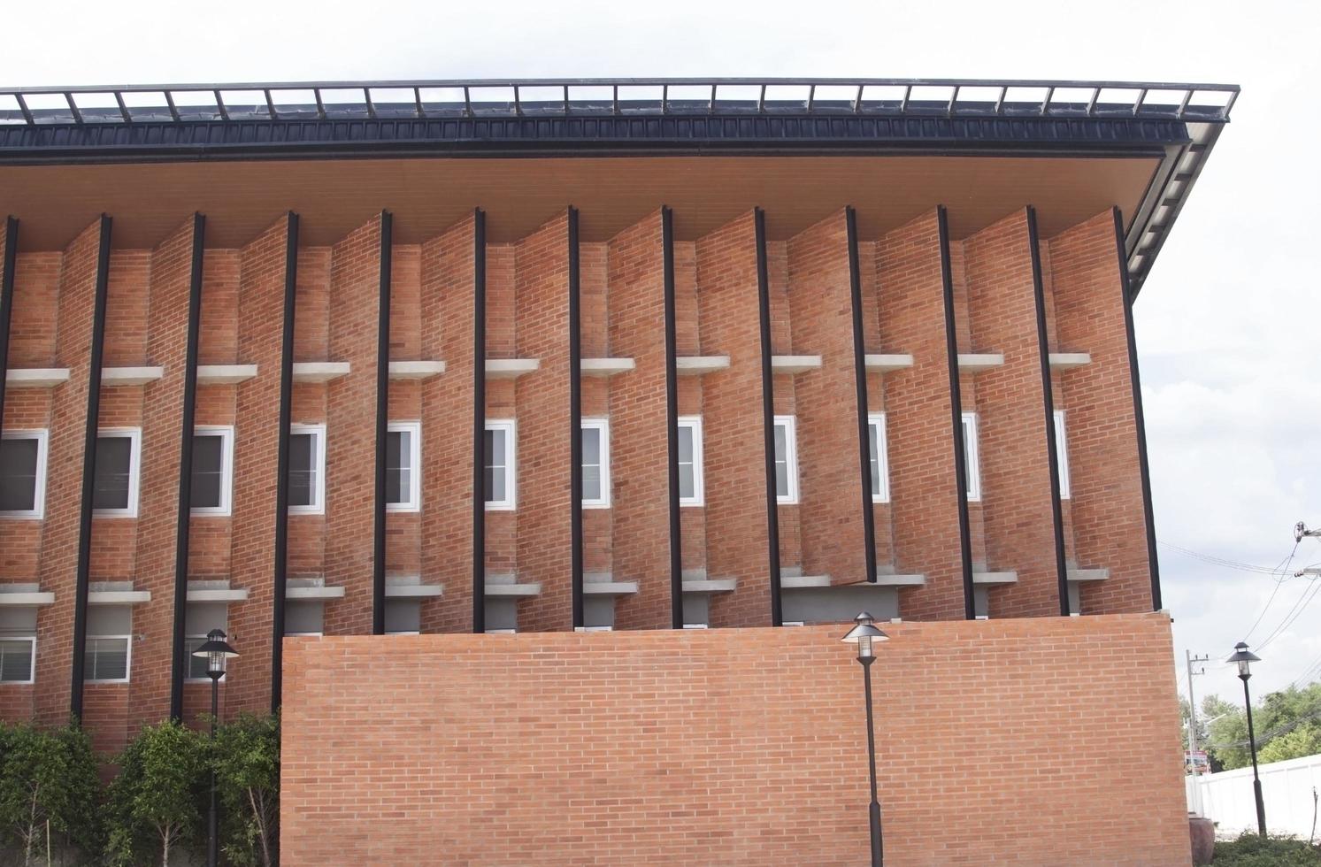 la construcción de ladrillo rojo es un edificio moderno y clásico con ventanas de ventilación y calor. foto