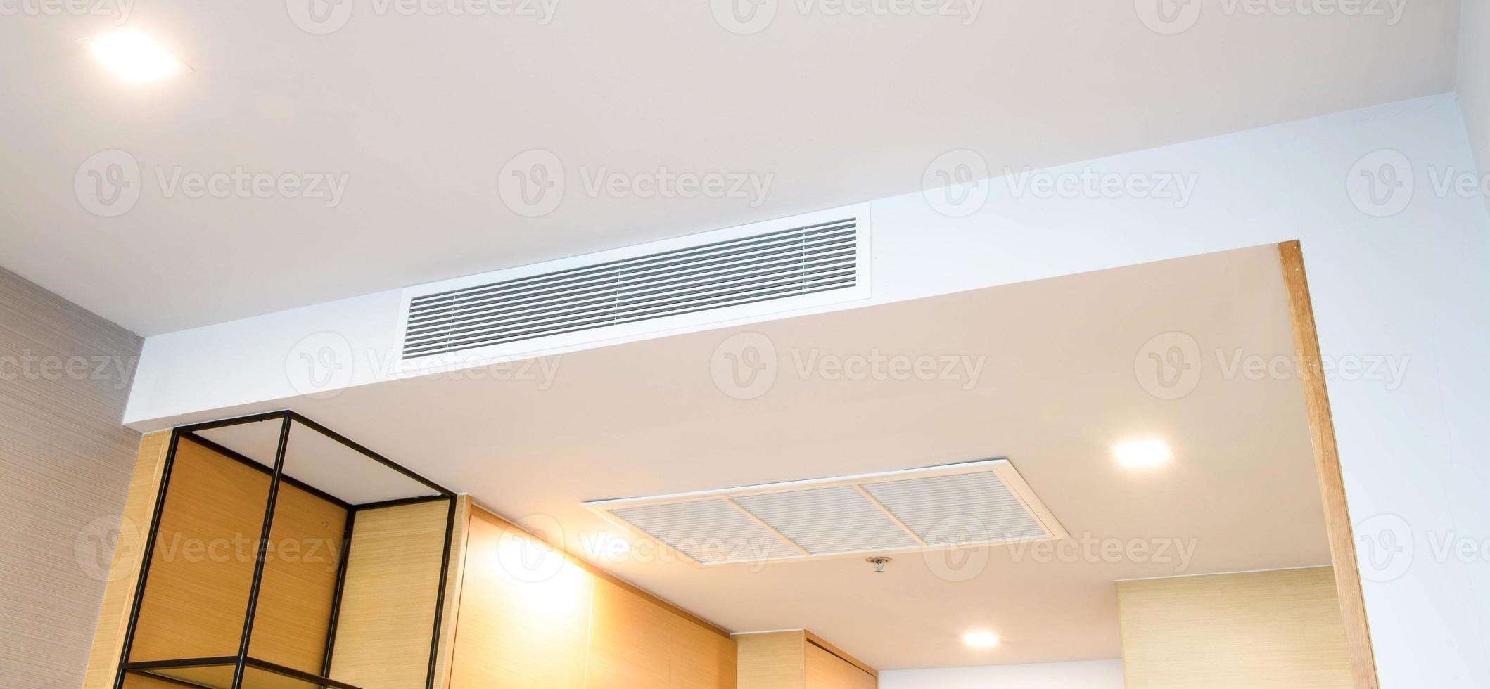 Ceiling mounted cassette type air conditioner and modern lamp light on white ceiling. duct air conditioner for home or office photo