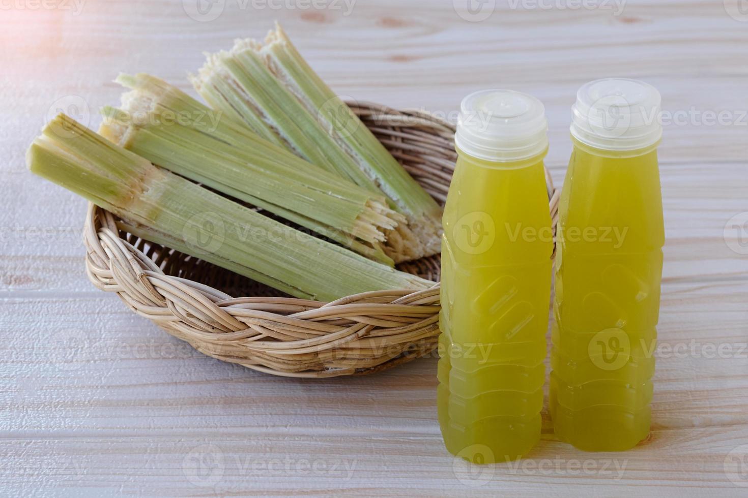 Bottles of fresh sugar cane juice.  and bagasse after squeezing for a drink in basket. Concept, healthy natural beverage made from agriculture crop. Homemade drinks, has medicinal , herbal properties photo