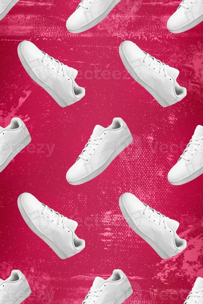 Pattern of white sneakers isolated on Viva Magenta grunge background. Sportive pair of shoes for mockup. Fashionable stylish sports casual shoes. Modern and minimalist wallpaper of fashion lifestyle. photo