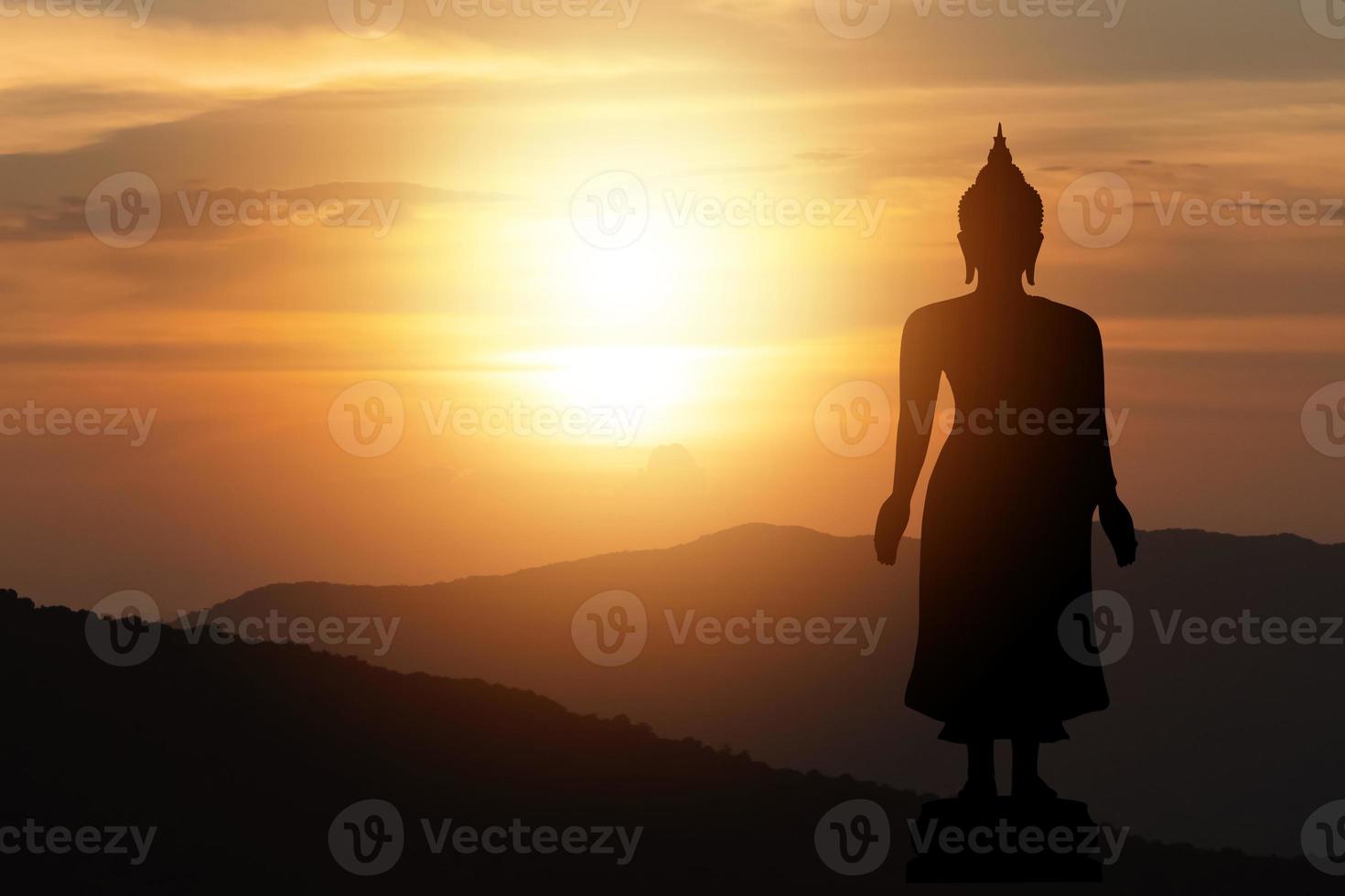 silueta gran estatua de buda sol brillando desde detrás del cielo de la montaña fondo de puesta de sol. día de makha bucha, día de vesak, asanha bucha, cuaresma budista. concepto de religión buda. foto