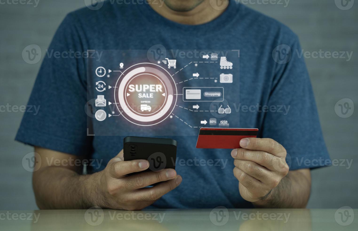 Man holding credit card and using mobile to shopping online on virtual digital screen. Shopping at home. Online shopping, e-commerce, internet banking, spending money, finance e-payment concept. photo