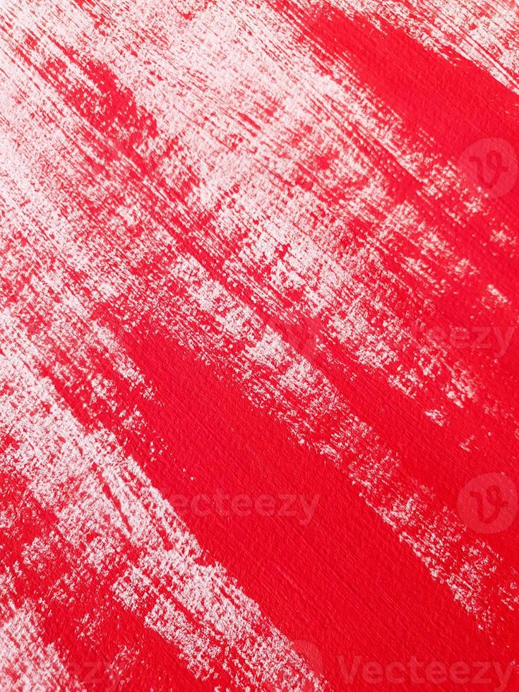 Abstract acrylic or gouache red paint on textured canvas paper. Brushstrokes of red paint. Vertical perspective artistic background with place for text. Selective focus, close up. photo