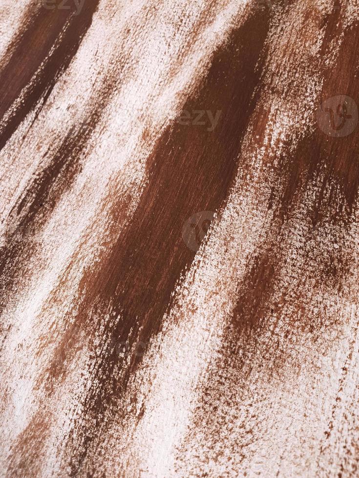 Abstract acrylic or gouache brown paint on textured canvas paper. Brushstrokes of dark brown paint. Vertical diagonal perspective artistic background with place for text. Selective focus, close up. photo