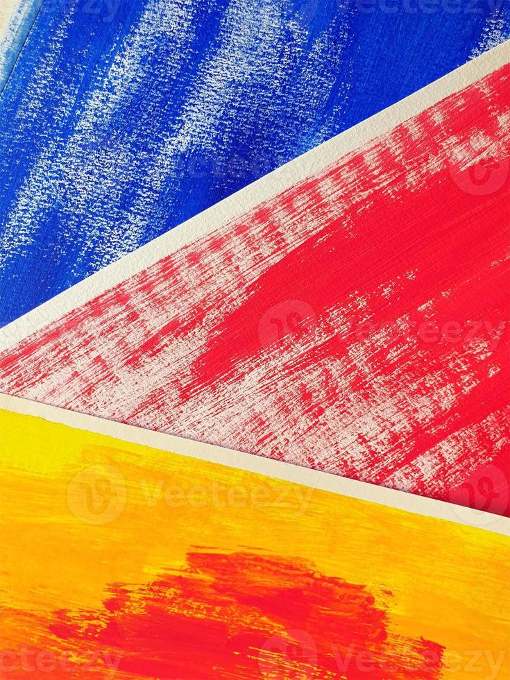 Three abstract drawings lie on surface, overlapping each other. Acrylic or gouache blue, red, yellow paint on texture paper. Partially visible, selective focus, close up, vertical image. photo