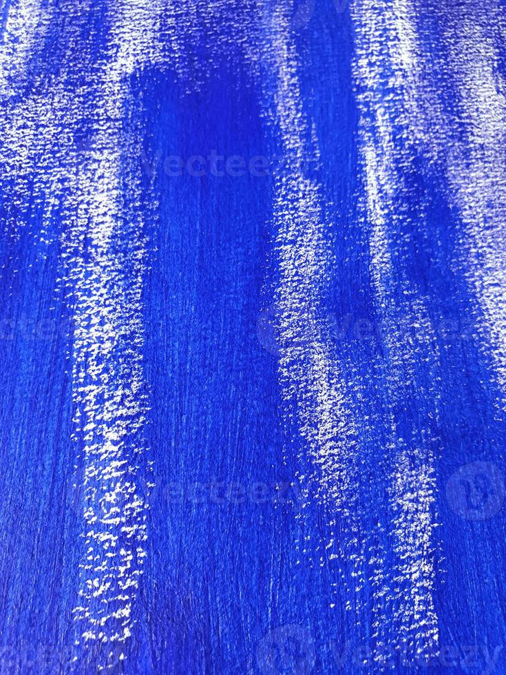 Artistic background with acrylic or gouache blue paint on textured canvas paper. Brushstrokes of dark blue paint. Vertical perspective abstract backdrop with copy space. Selective focus, close up. photo
