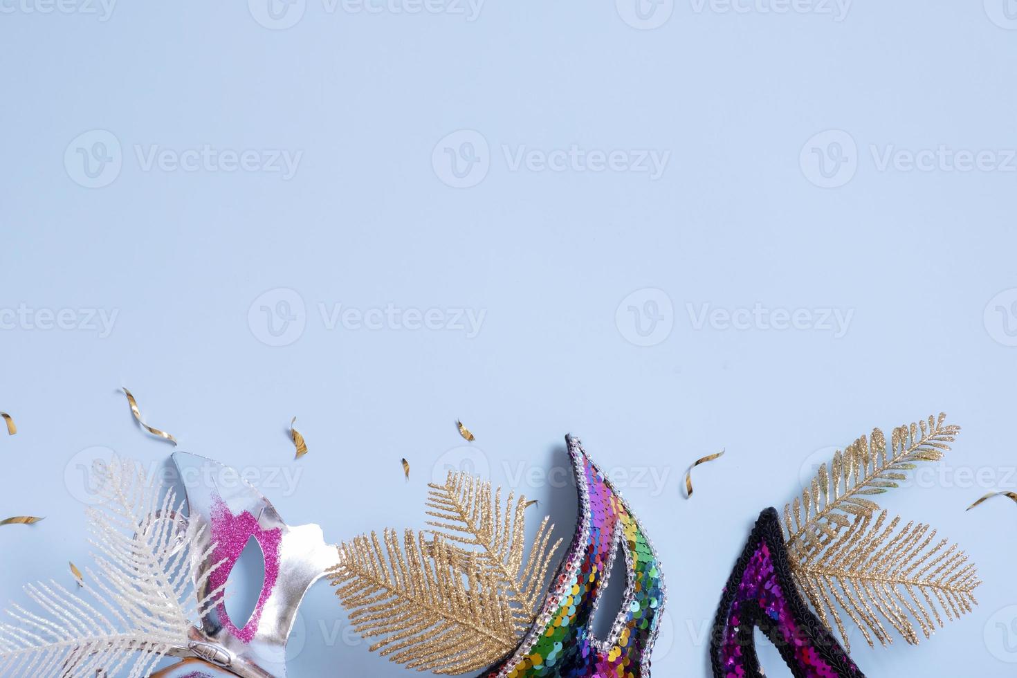 Festive face masks for carnival celebration on colored background with copy space. Carnival flat lay concept. photo