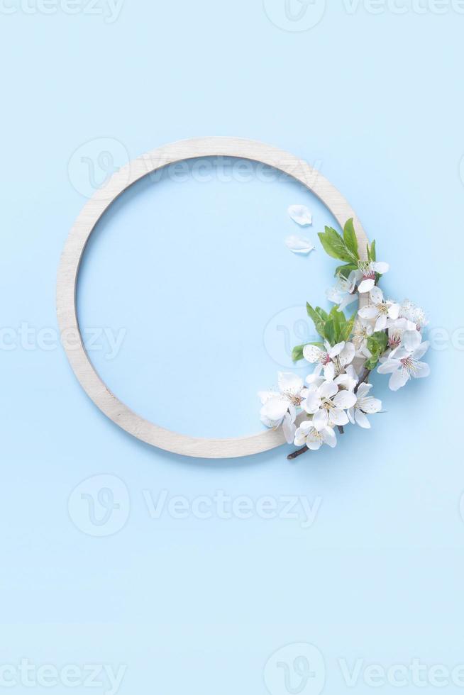 Round wooden frame with flower and leaves mock up flat lay for your text photo