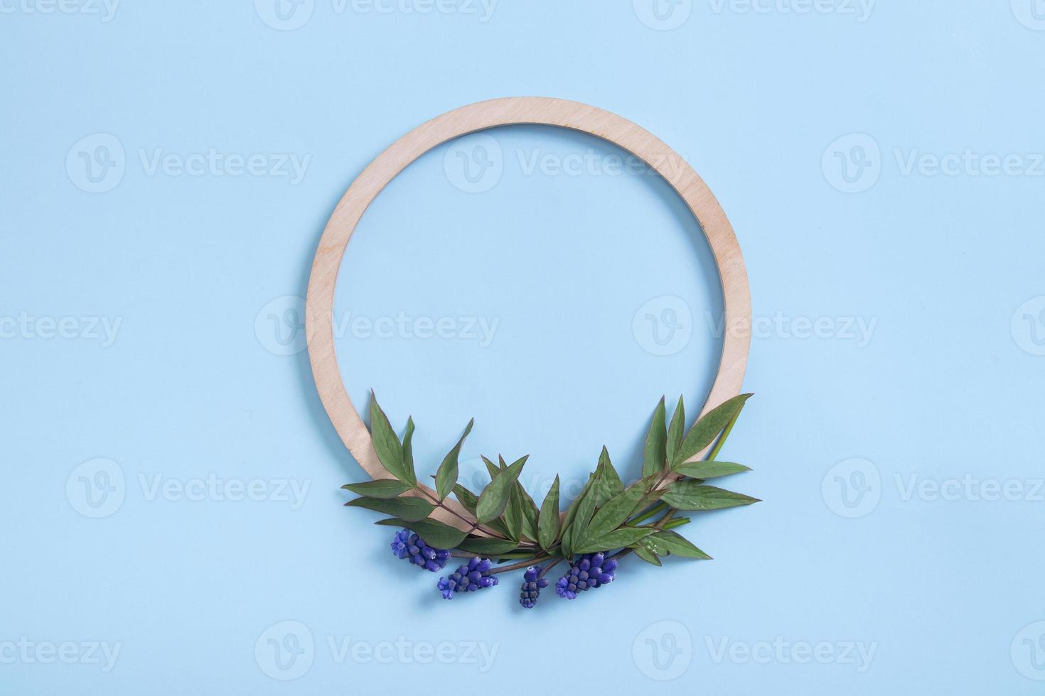 Round wooden frame with flower and leaves mock up flat lay for your text photo