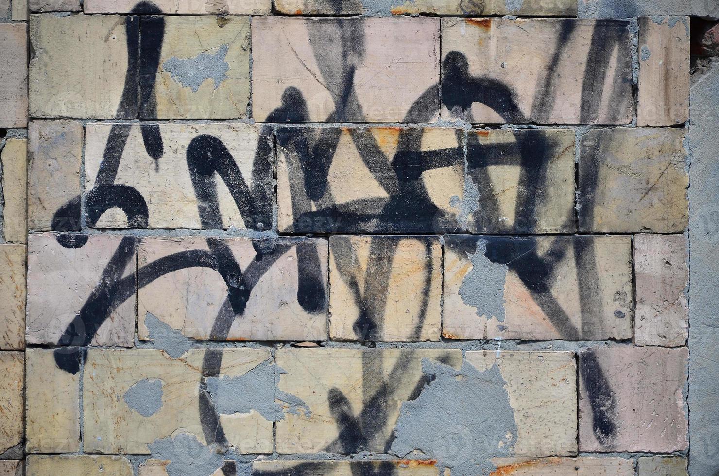 Texture of a fragment of the wall with graffiti painting, which is depicted on it. An image of a piece of graffiti drawing as a photo on street art and graffiti culture topics