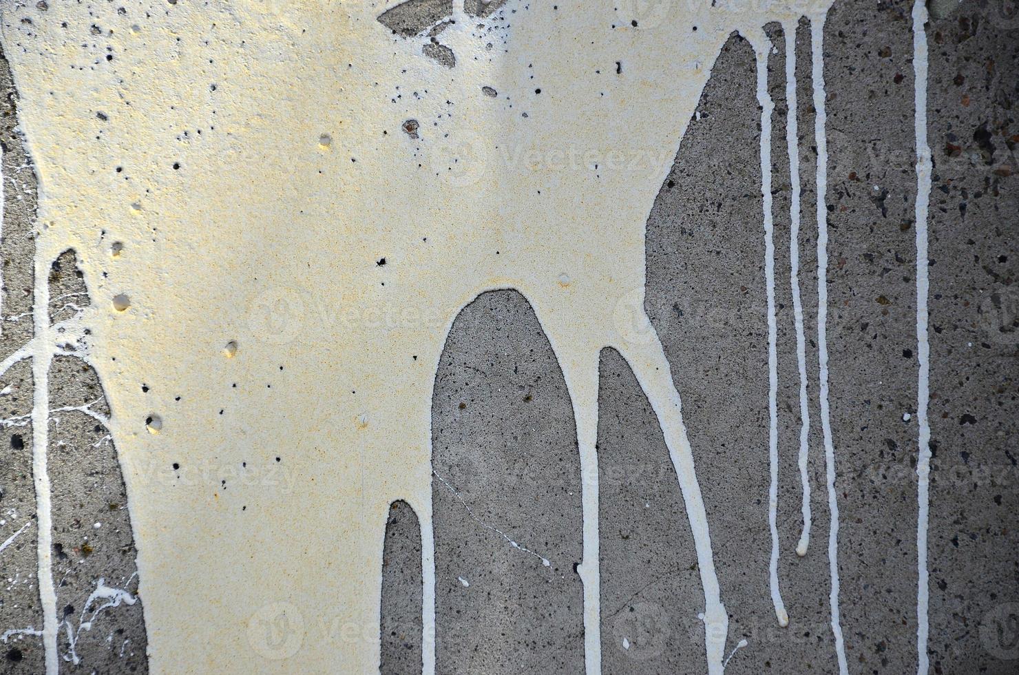 A photograph of a close-up of black paint spots on a concrete wall. Pouring paint on the wall in random order. The concept of graffiti and street art culture photo