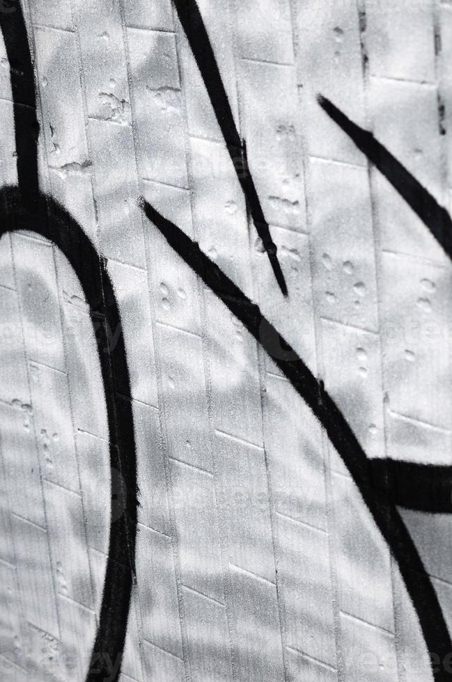 A fragment of a graffiti pattern, applied to a wall of cold tiles, which is covered with a fine condensate. The concept of street art in inappropriate weather photo