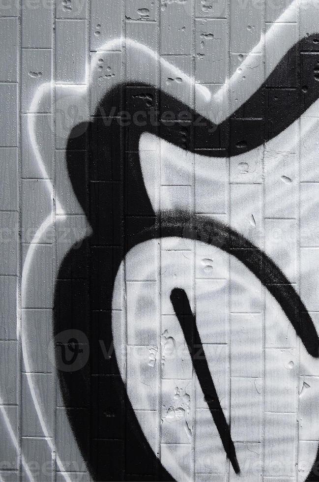 un fragmento de un patrón de graffiti, aplicado a una pared de azulejos fríos, que está cubierta con un fino condensado. el concepto de arte callejero en un clima inapropiado foto