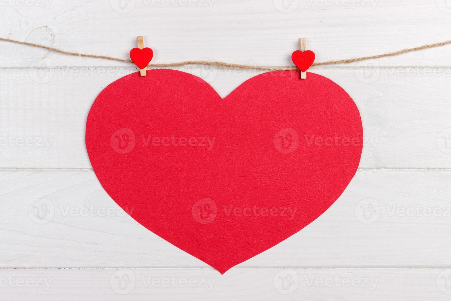 Big love red heart hanging on wooden texture background, valentines day card concept photo