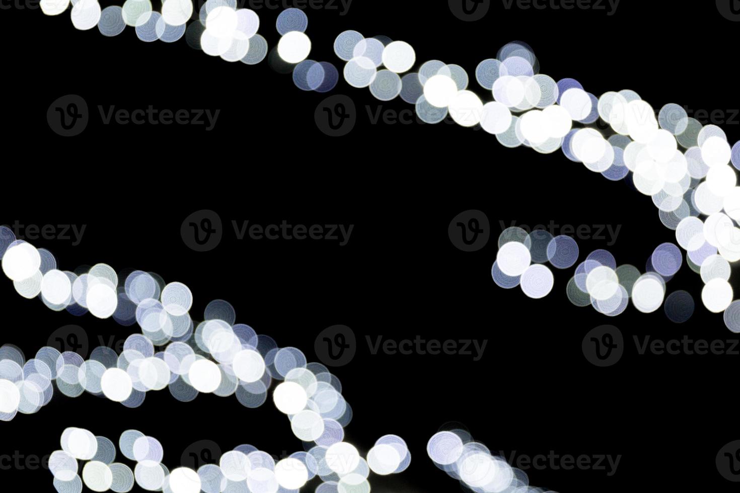 Abstract bokeh of white city lights on black background. defocused and blurred many round light photo