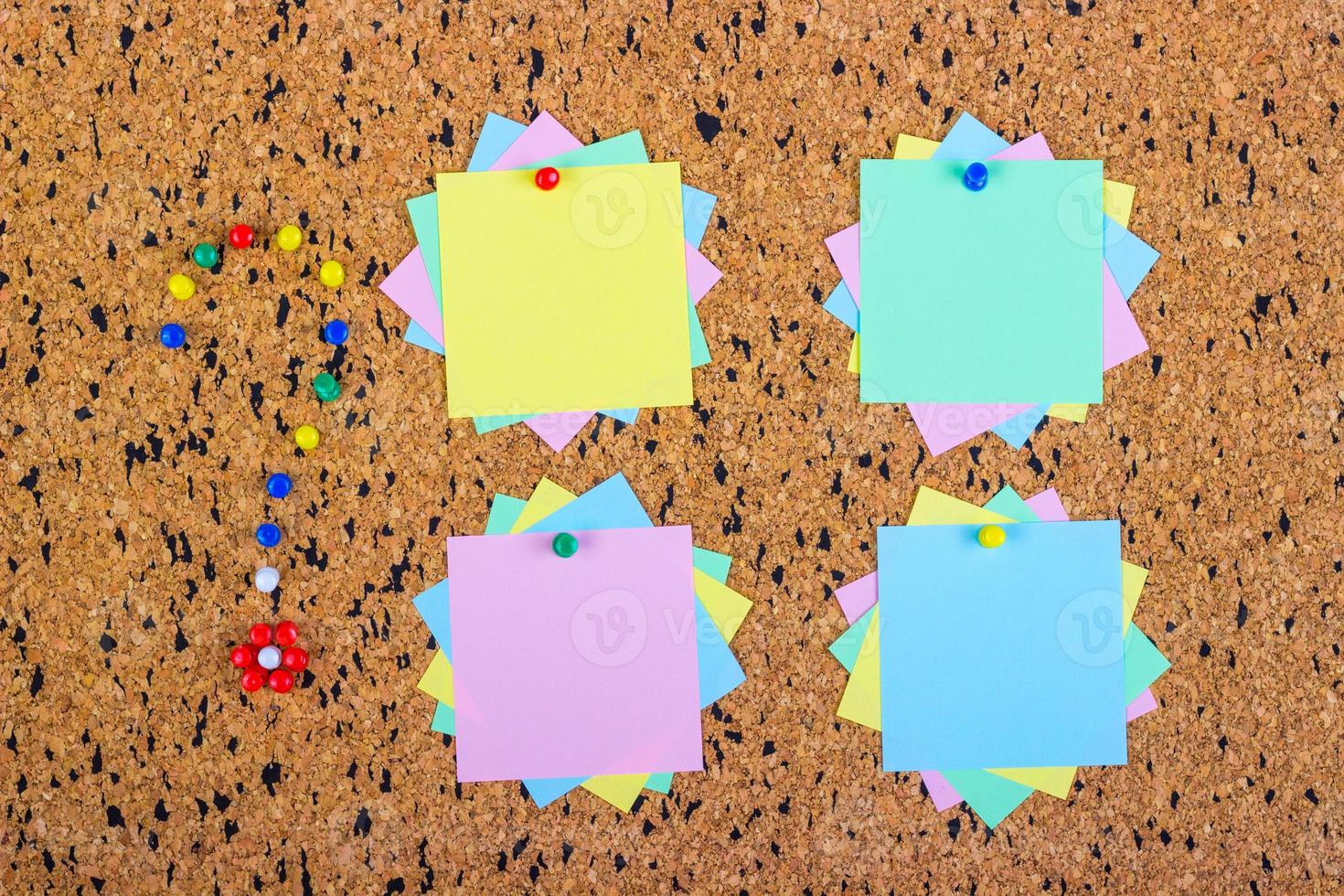 colorful sticky notes on cork bulletin board. Question mark made of pushpins photo