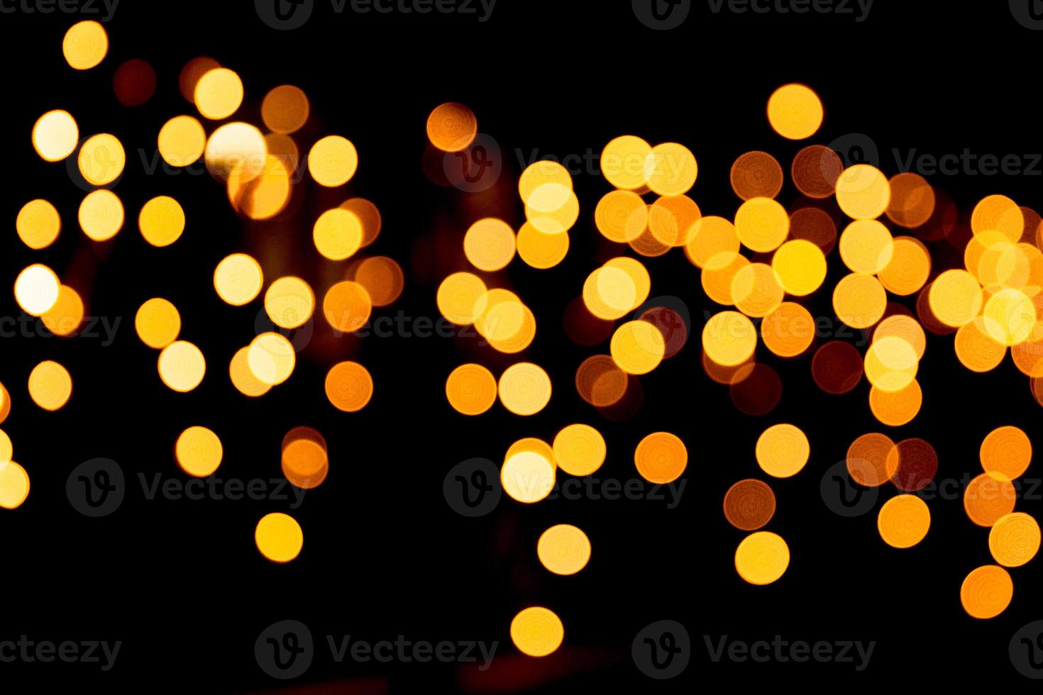 Festive abstract gold background with bokeh defocused and blurred many round yellow light on Christmas dark background photo