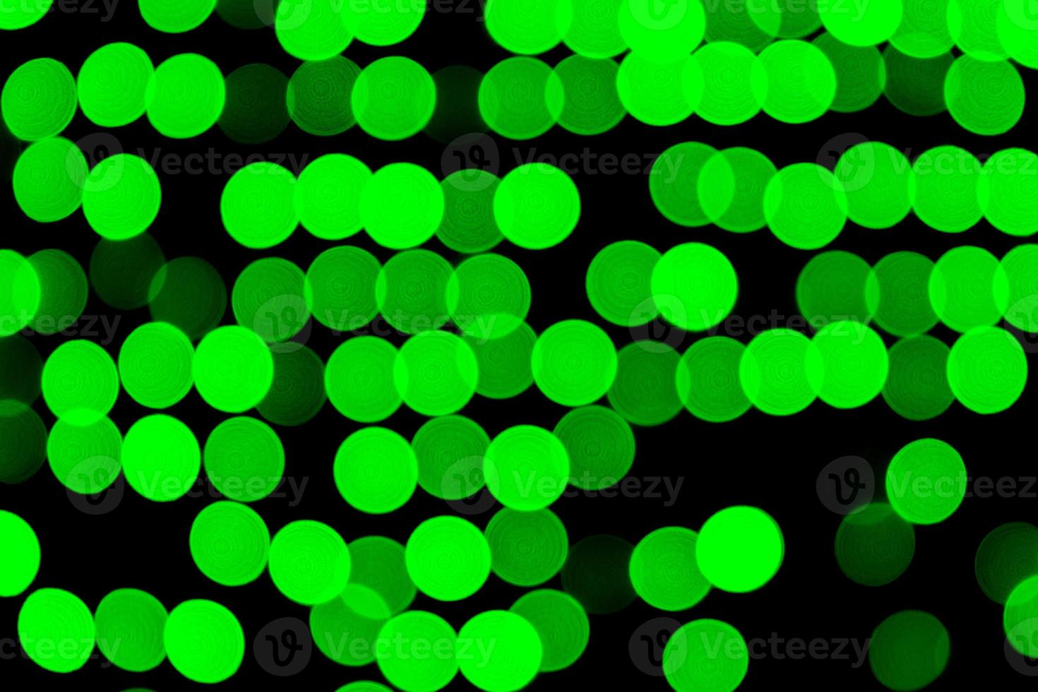 Unfocused abstract green bokeh on black background. defocused and blurred many round light photo