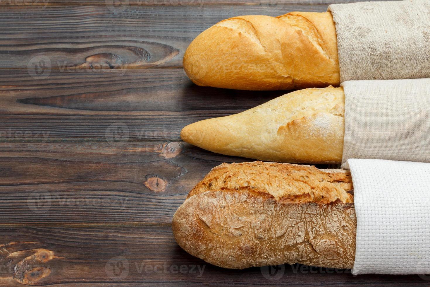 Assortment of fresh French baguettes on a wooden table photo