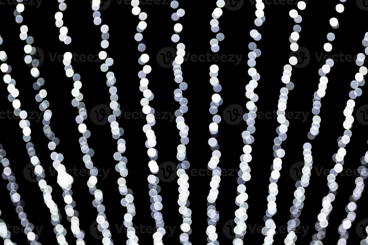 Abstract bokeh of white city lights on black background. defocused and blurred many round light photo