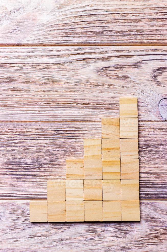 A wooden blocks cube over black wooden textured background with copy space for add word text title. Concept or conceptual Wood block stair or six steps. Cubic photo
