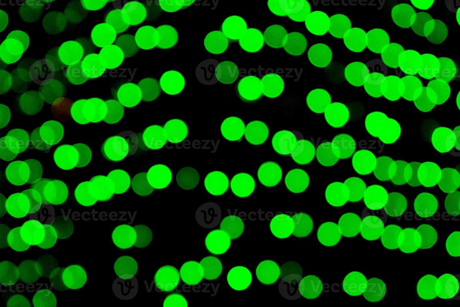 Unfocused abstract green bokeh on black background. defocused and blurred many round light photo