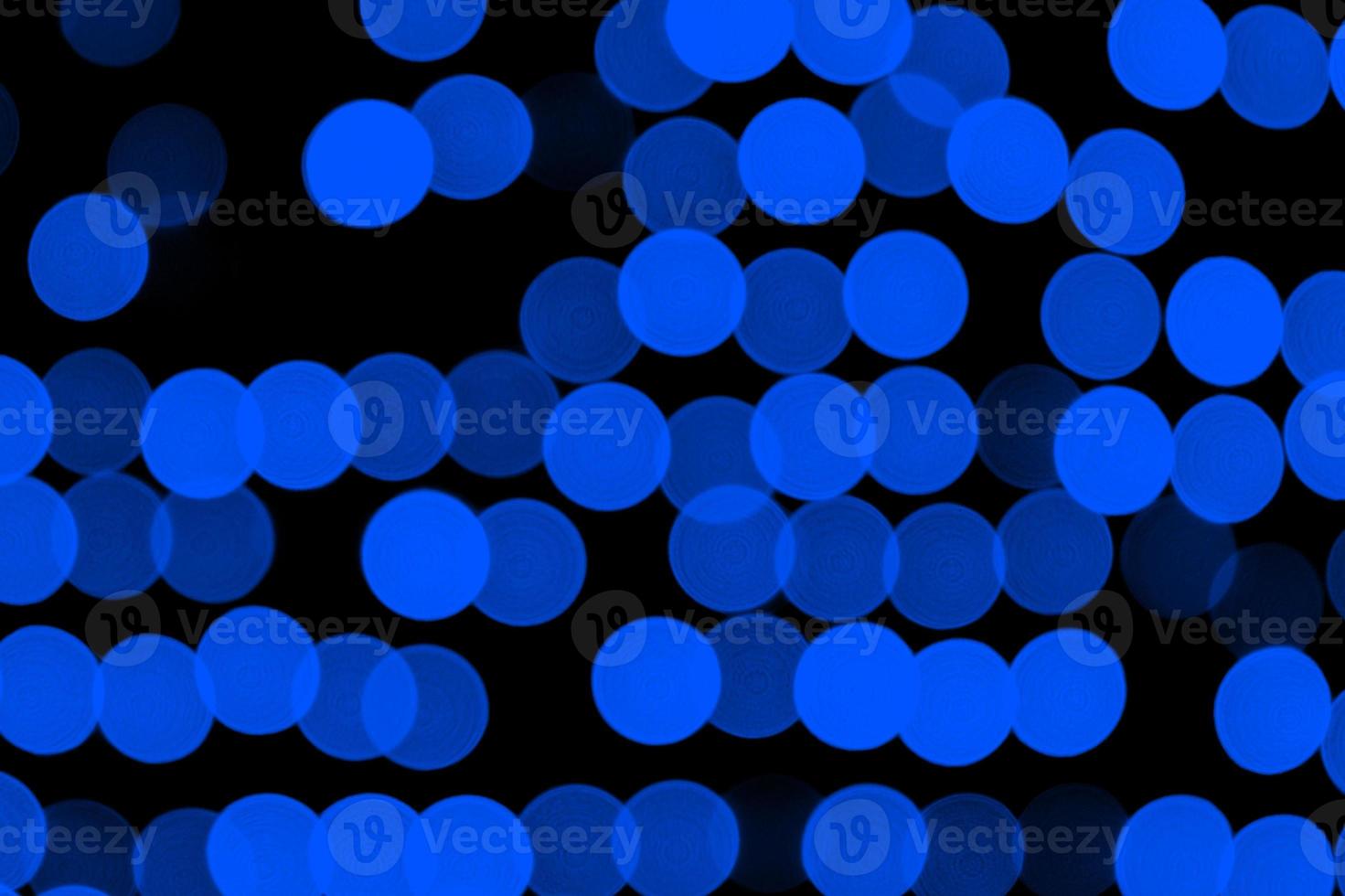 Unfocused abstract dark blue bokeh on black background. defocused and blurred many round light photo